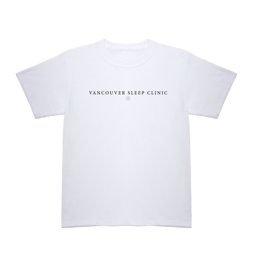 A plain white T-shirt from Vancouver Sleep Clinic features VANCOUVER SLEEP CLINIC in bold black capital letters across the chest, with a small circular symbol below the text.
